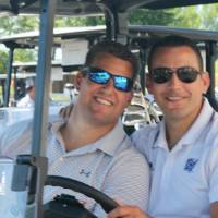 2 alumni in golf cart